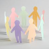 Paper cut outs of a diverse group of people holding hands in a circle. 