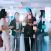 Group of workers at a window with sticky notes
