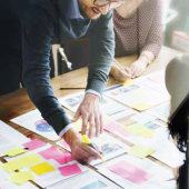 business people marking documents with highlighters and sticky notes